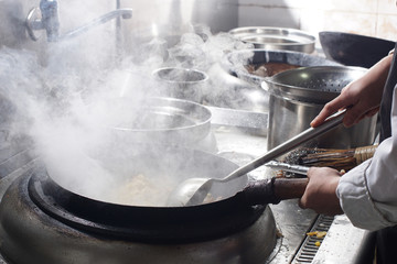 Close up of working chef preparing chinese food