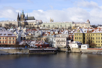 Fototapeta premium Snowy freeze Prague Lesser Town with gothic Castle above River Vltava, Czech republic