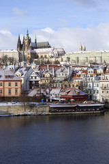 Snowy freeze Prague Lesser Town with gothic Castle above River Vltava, Czech republic