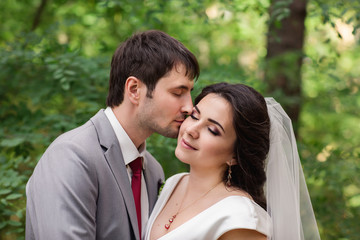 Portrait of kissing couple, beautiful bride and groom at wedding day
