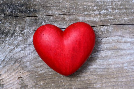 Red hart on wooden background - love symbol
