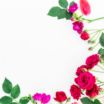 Frame with red roses and freesia, branches, leaves and petals isolated on white background. flat lay, overhead view