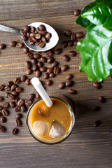 coffee with ice in glass on wooden background top view