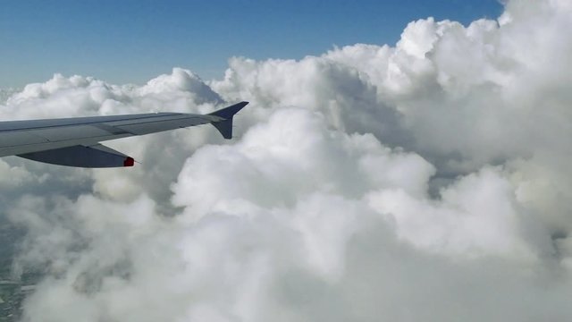 Jet Plane Flying Through Cumulus Clouds