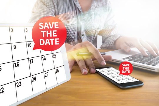 SAVE THE DATE message on hand holding to touch a phone, top view