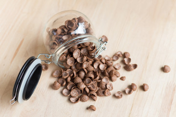 Chocolate cereal cornflakes spilling to the wood surface