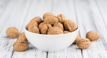 Whole Walnuts on wooden background (selective focus)