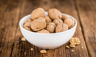 Portion of Whole Walnuts on wooden background (selective focus)