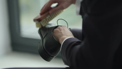 SLO MO CLOSE UP Man polishing black leather shoe