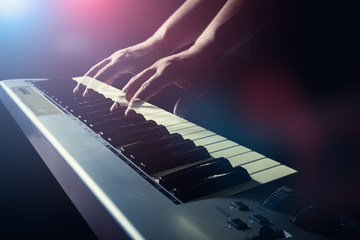 Musician's hand is playing a keyboard