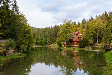 Fototapeta na wymiar House near the lake in the forest, autumn day.
