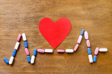 Red heart with pills on table