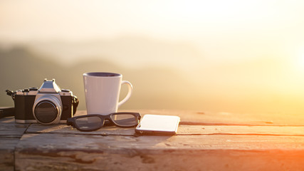 Cup with tea on table over mountains landscape with sunlight vintage. Beauty nature background