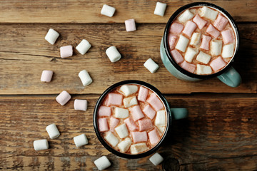 Cups of hot cocoa with marshmallows on table
