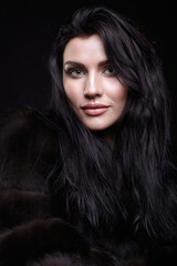 Portrait of a young brunette woman with long black hair dressed