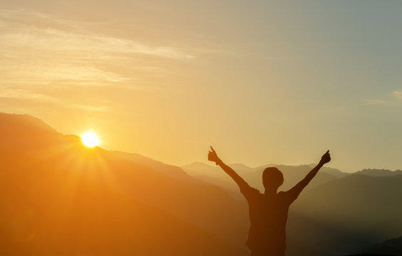 Man Silhouette Raised Up hands at Mountain with Sunrise in Morni