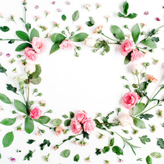 Naklejka na ściany i meble Round frame made of pink and beige roses, green leaves, branches, floral pattern on white background. Flat lay, top view. Valentine's background