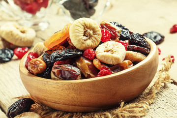 Healthy food: mix from dried fruits in bowl, old wooden backgrou