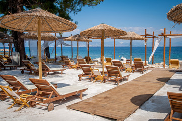 Beach with wooden umbrellas and sunbeds