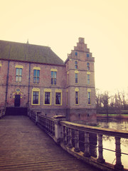 Ancient medieval stone fortress surrounded by water channel, cas