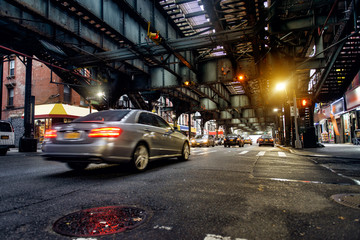 Above ground subway line and New York City street in Brooklyn with cars. City backround.