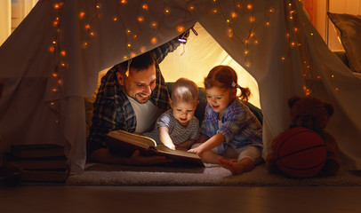 happy family father and children reading a book  in  tent at hom © JenkoAtaman