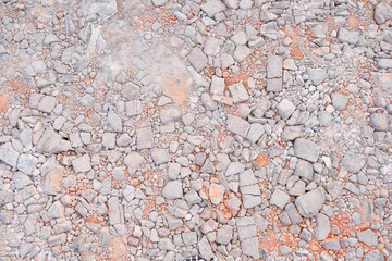 a ground of dirt rocks and cracked bricks