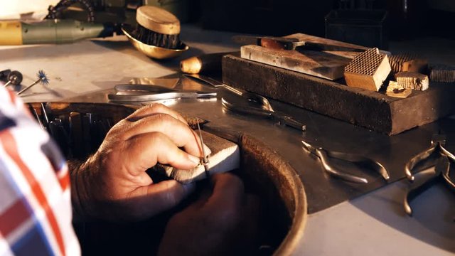 Attentive goldsmith working in workshop 4k