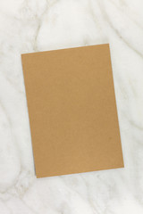 Brown kraft card on white marble texture