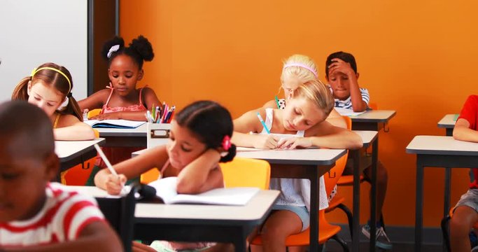 School kids doing their homework in classroom at school 4k