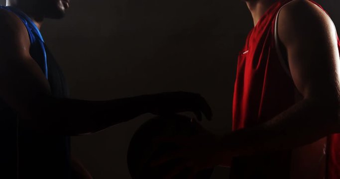 Basketball players challenging each other face to face in basketball court 4k