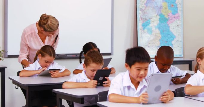 Students using digital tablet in classroom at school 4k