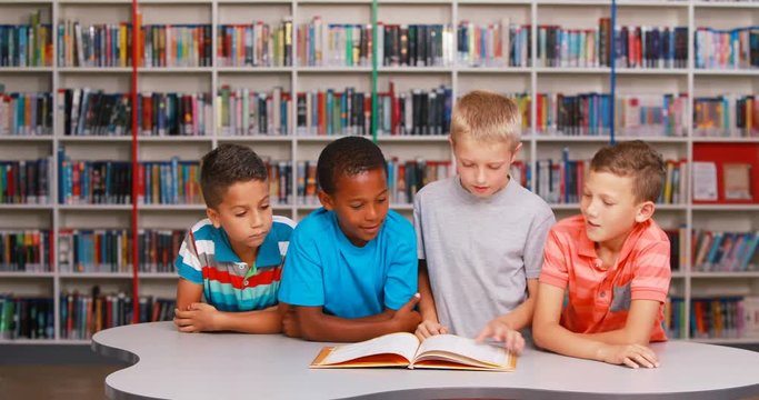 School kids reading book together in library at elementary school 4k
