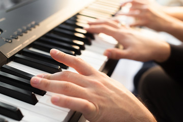 Closeup of hands playing piano. Music and hobby concept