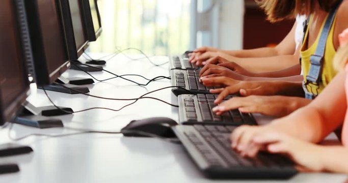Schoolgirls using computer in classroom at school 4k