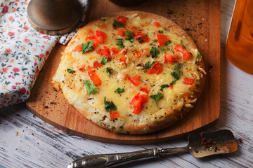 homemade pizza with a mini board tomatoes and herbs
