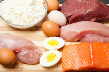Proteins, fish, cheese, eggs, meat and chicken on a black background - 134560178