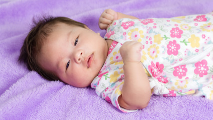 Portrait of adorable baby girl lying on the bed