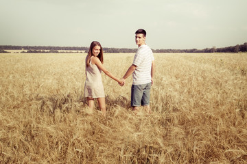love couple walking in field holding hands