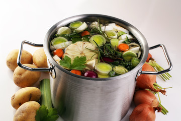 Broth with carrots, onions various fresh vegetables in a pot - c