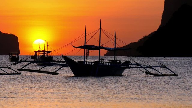 Traditional filippino boats at El Nido bay in sunset lights. Palawan island, Philippines. UHD, 4K