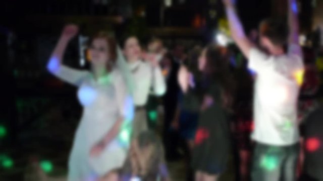 bride with friends in evening dresses dancing in the club light show camera blur