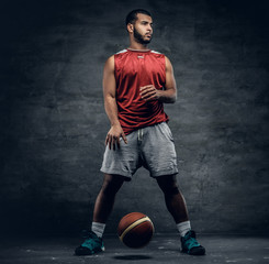 A black basketball player playing with a ball.