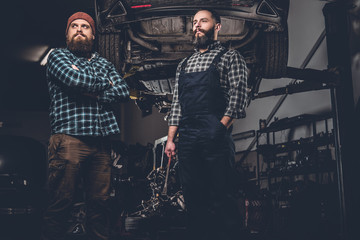 Obraz na płótnie Canvas Two bearded mechanics in a garage.