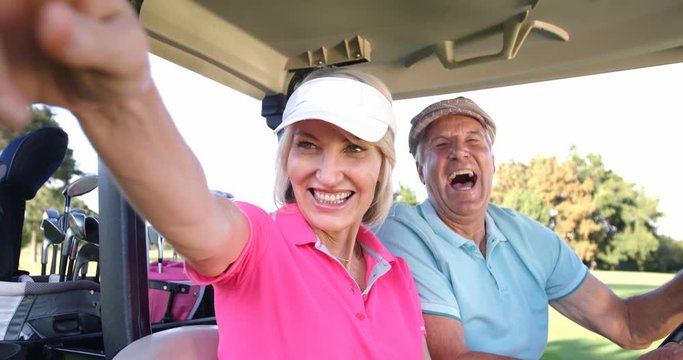 Two golfers driving in their golf buggy at golf course