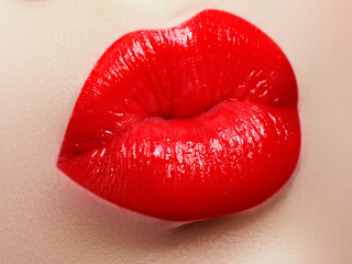 Cosmetics and makeup. Red lip gloss and lipstick. Fashion lip makeup. Sensual female mouth. Closeup...
