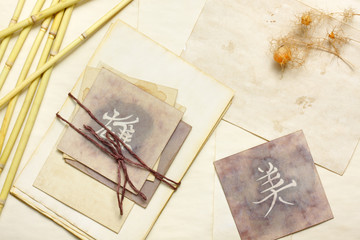 Nostalgic vintage still life with aged cards with japanese and chinese words and dried plants