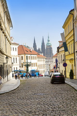 Obraz premium Prague, narrow street and spikes of the Cathedral