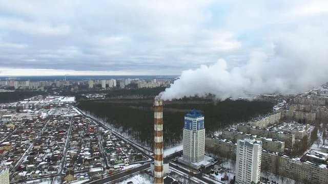 
4K Aerial. Winter modern city with smoke of pipe power plant. Lateral flight.

