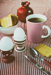 Hard boiled eggs, tea and cookies served in the dotted, striped and checkered red and white crockery